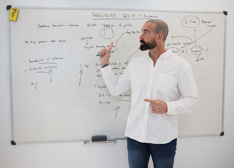 Pablo Álvarez señalando un esquema en la pizarra durante una tutoría con alumnos